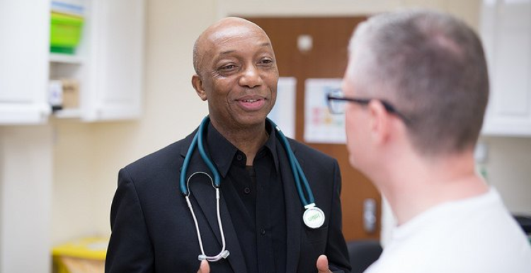 A doctor talking to a man in hospital setting