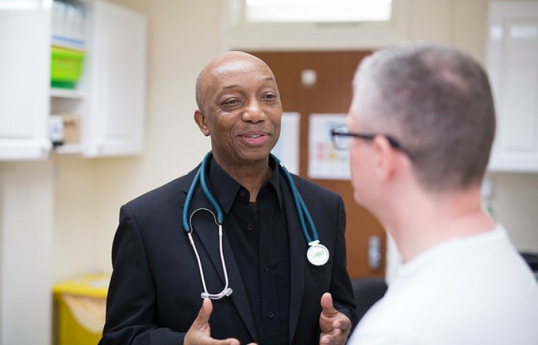 A doctor talking to a man in hospital setting
