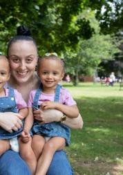 Woman with twin baby girls smiling at the camera