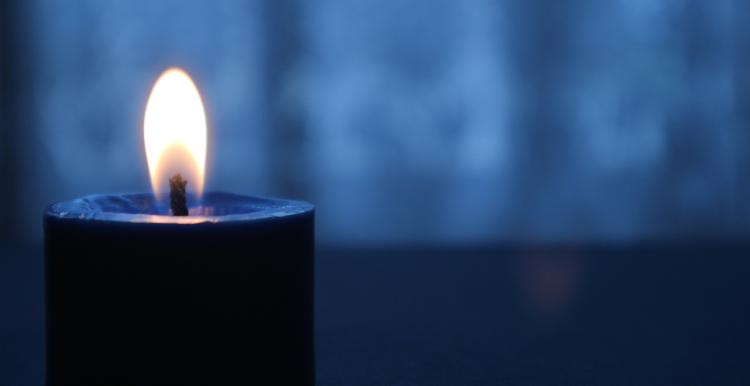 A lit candle in a dark room