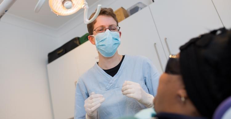 A dentist treating a patient in treatment room