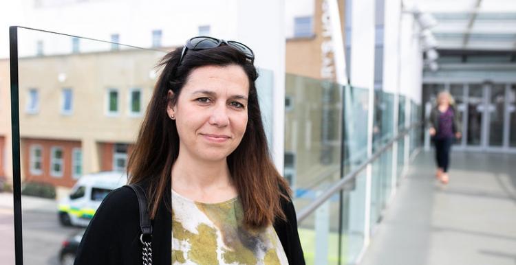 Woman outside hospital building looking at camera 