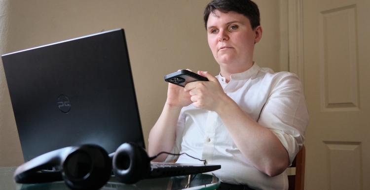 Visually impaired person using a screen reader to access information from a laptop computer