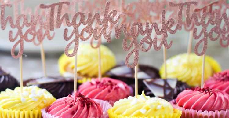 Brightly coloured cupcakes with thank you labels stuck into them