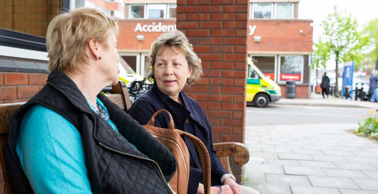 two women talking outside a hospital