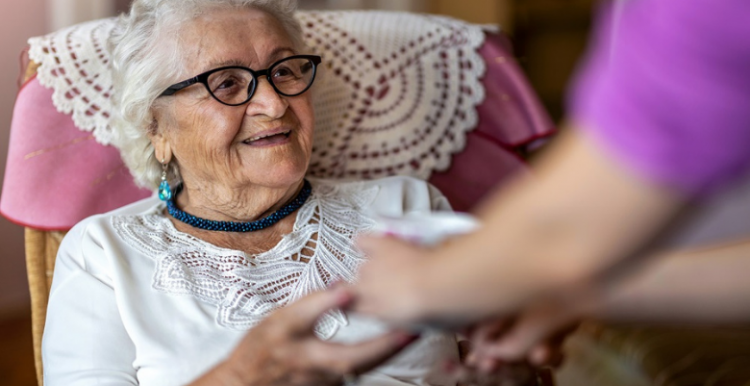 Keeping safe during visits to care homes elderly woman at a care home welcomes a visitor