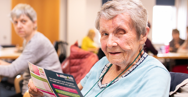 older woman holding a flyer 