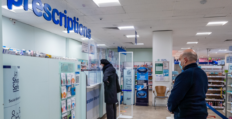 people queuing for prescriptions at a pharmacy