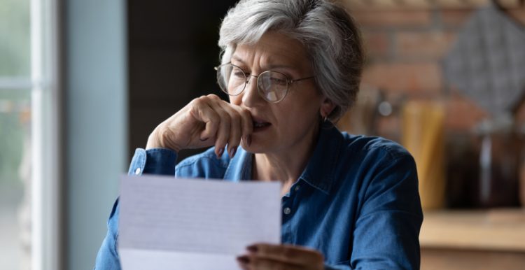 Woman looking at bill with worried expression on her face 