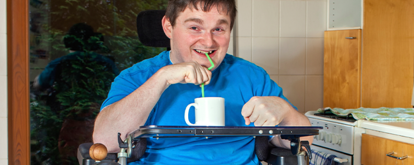 Man in wheelchair inside - having a drink