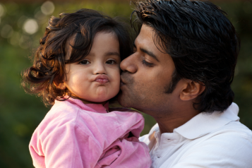 Man cuddling his toddler daughter