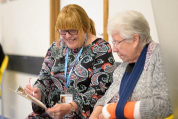 A Healthwatch worker helping an older woman complete a form