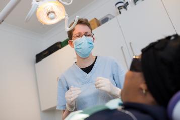 A dentist treating a patient in treatment room