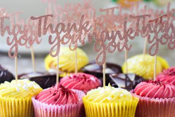 Brightly coloured cupcakes with thank you labels stuck into them
