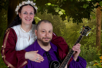 woman in medieval dress and man playing musical instrument