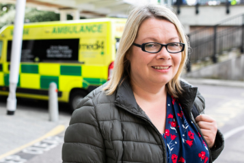 woman at hospital with ambulance in background