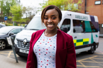 woman with an ambulance in the background