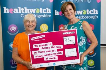 Two women holding a mental health support pledge 