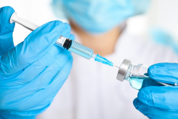 A doctor fills a vaccine syringe
