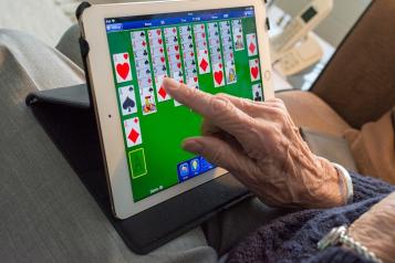 elderly lady playing game on tablet