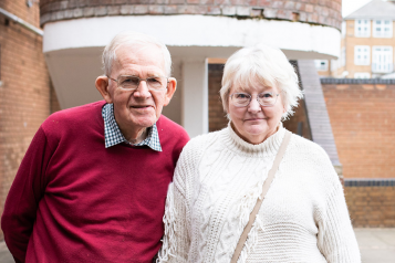 Picture shows older mana nd woman standign looking at the camera at a Healthwatch event