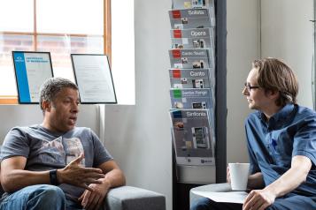 Two men in a waiting room area having a conversation