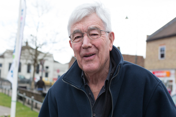 Older man standing outside looking at camera 