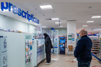 people queuing for prescriptions at a pharmacy