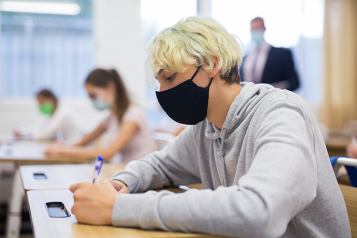 Picture shows young people wearing face coverings in classroom setting 