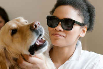 woman wearing dark glasses with a guide dog