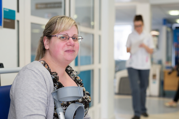 Woman with crutches in hospital waiting room