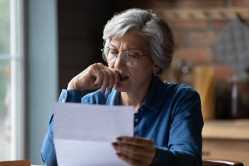 Woman looking at bill with worried expression on her face 